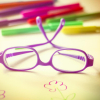Eine Kinderbrille und Farbstifte