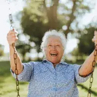 ältere Dame auf einer Schaukel